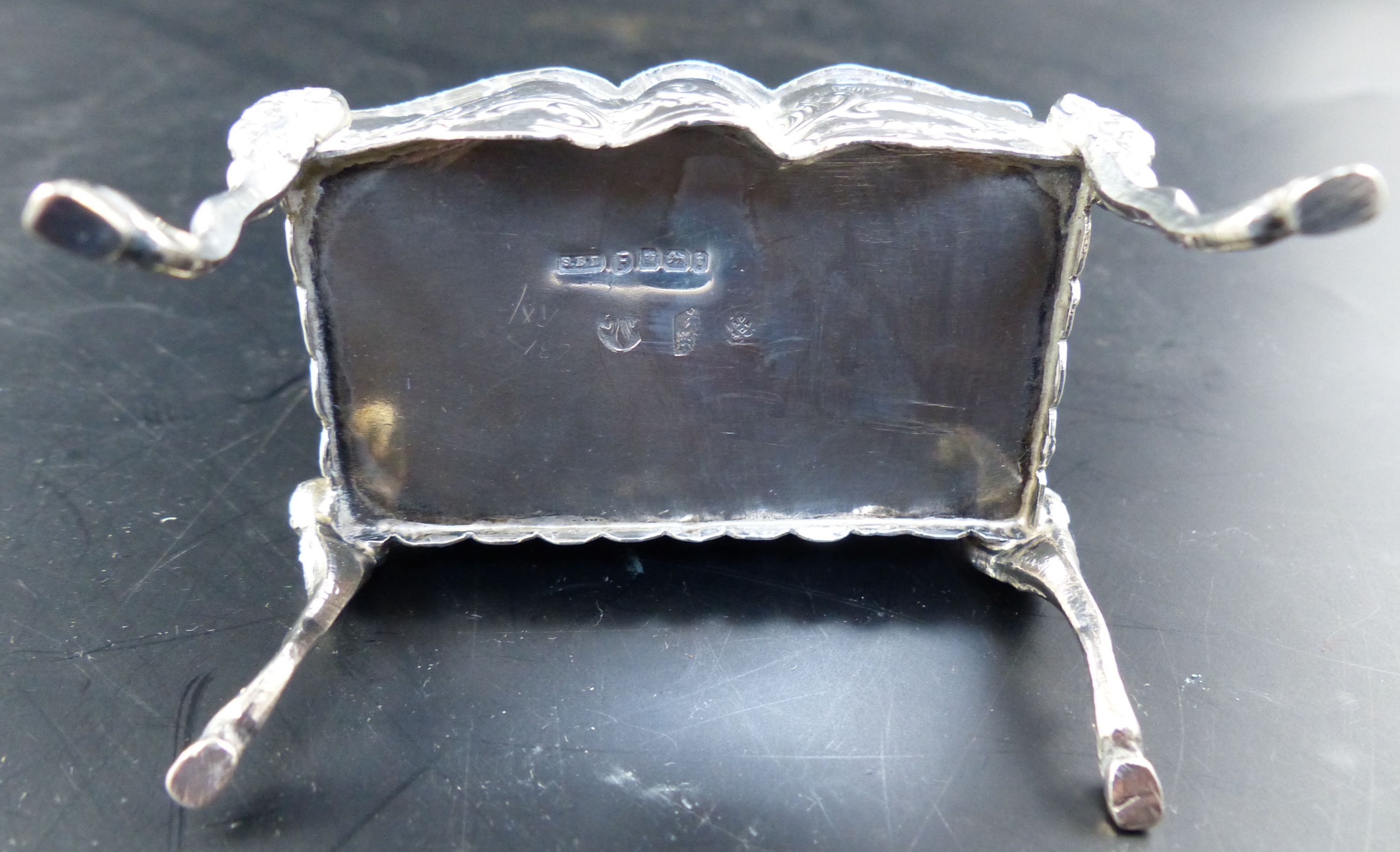A Hanau embossed silver trinket box, formed as a miniature bureau on mask and hoof feet, width 2.5in,